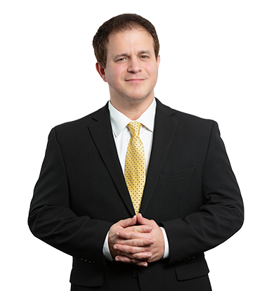 Attorney Ernesto Gonzalez in a suit and tie with his hands folded