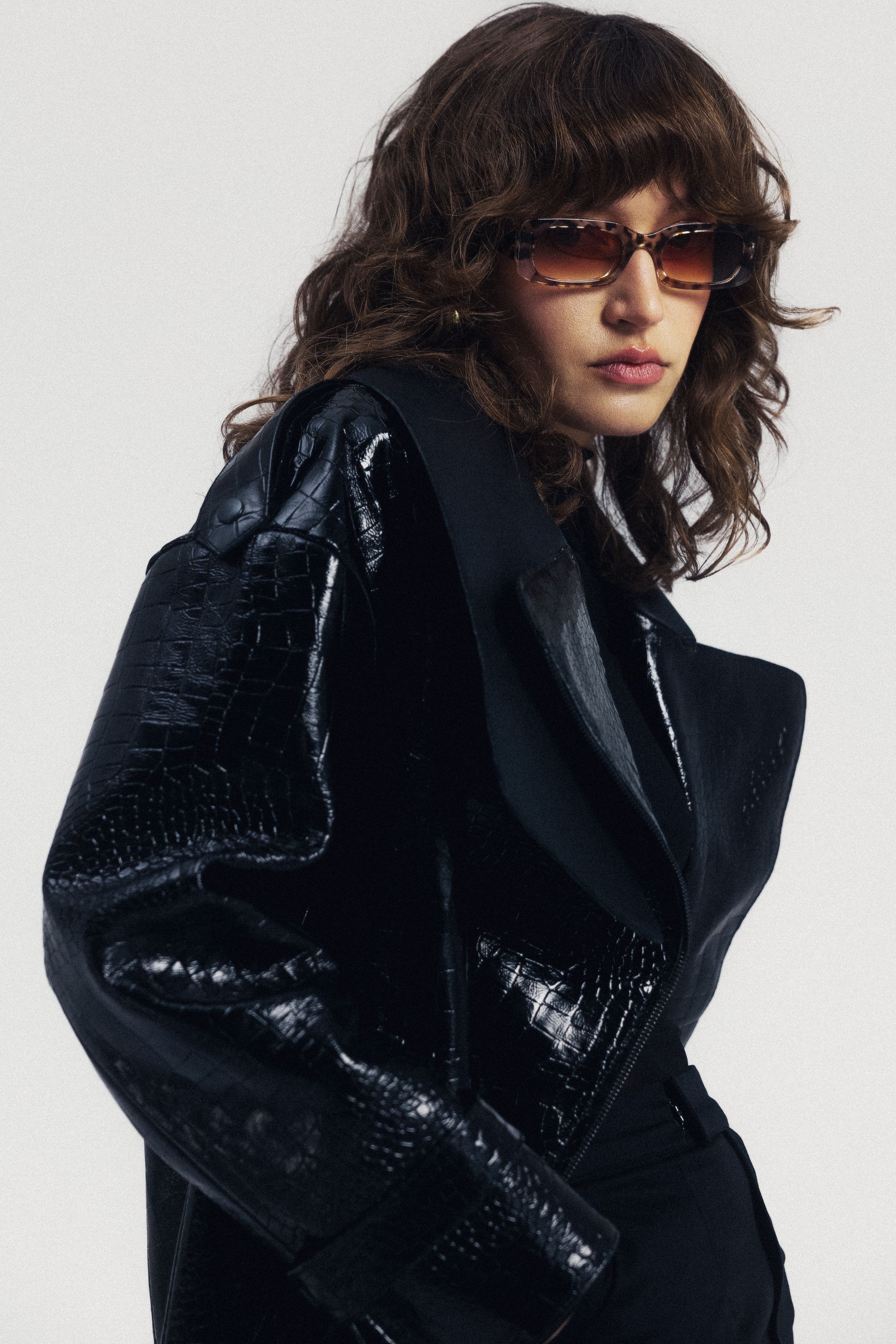 Kobieta w okularach przeciwsłonecznych i czarnej kurtce