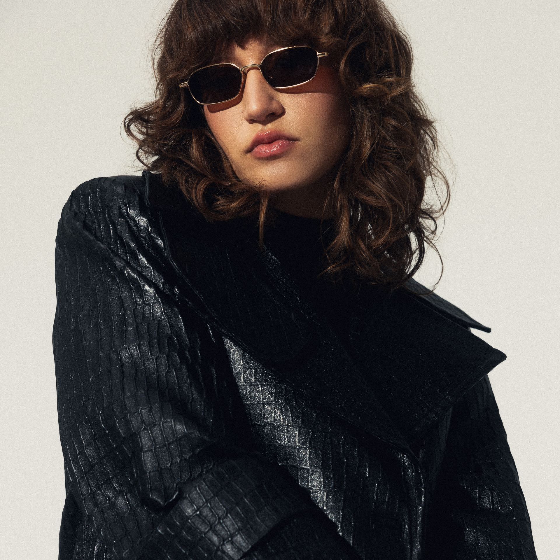 Kobieta w okularach przeciwsłonecznych i czarnej kurtce