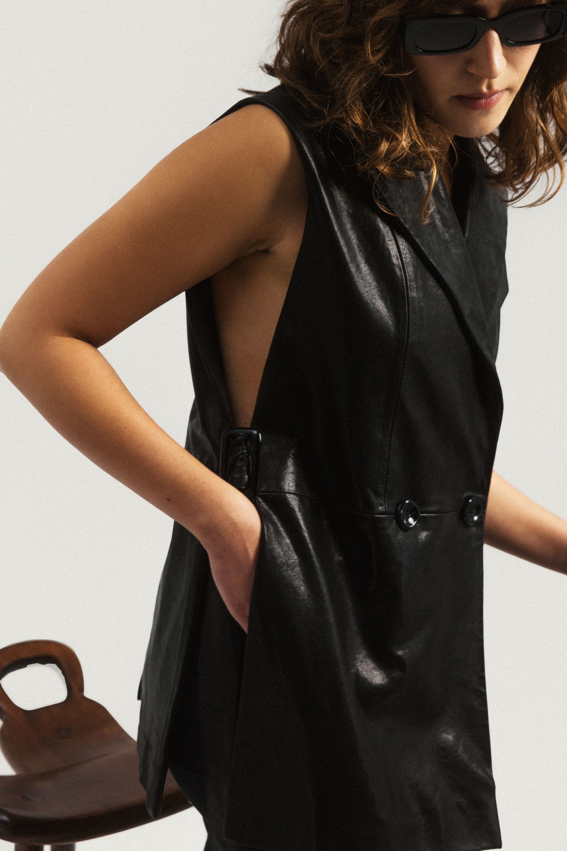 Kobieta w okularach przeciwsłonecznych i czarnej skórzanej kamizelce