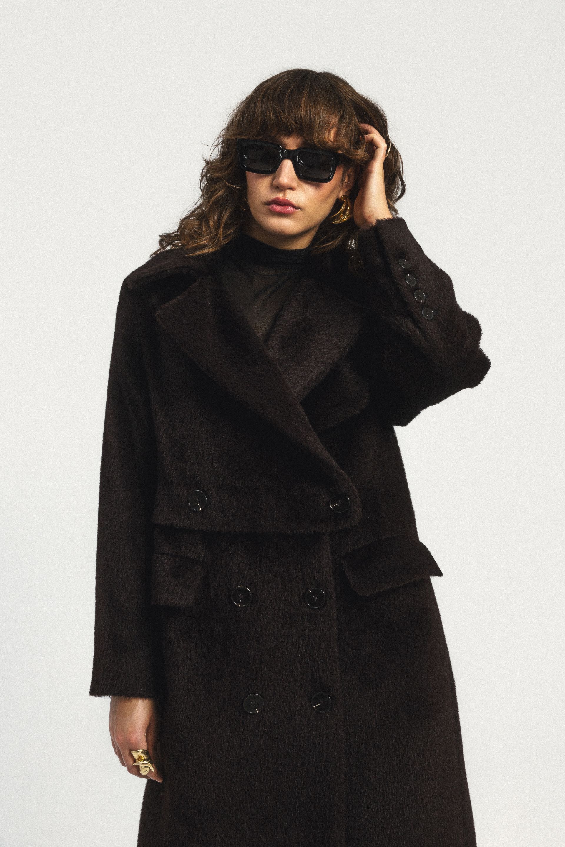 Kobieta w okularach przeciwsłonecznych i czarnym płaszczu