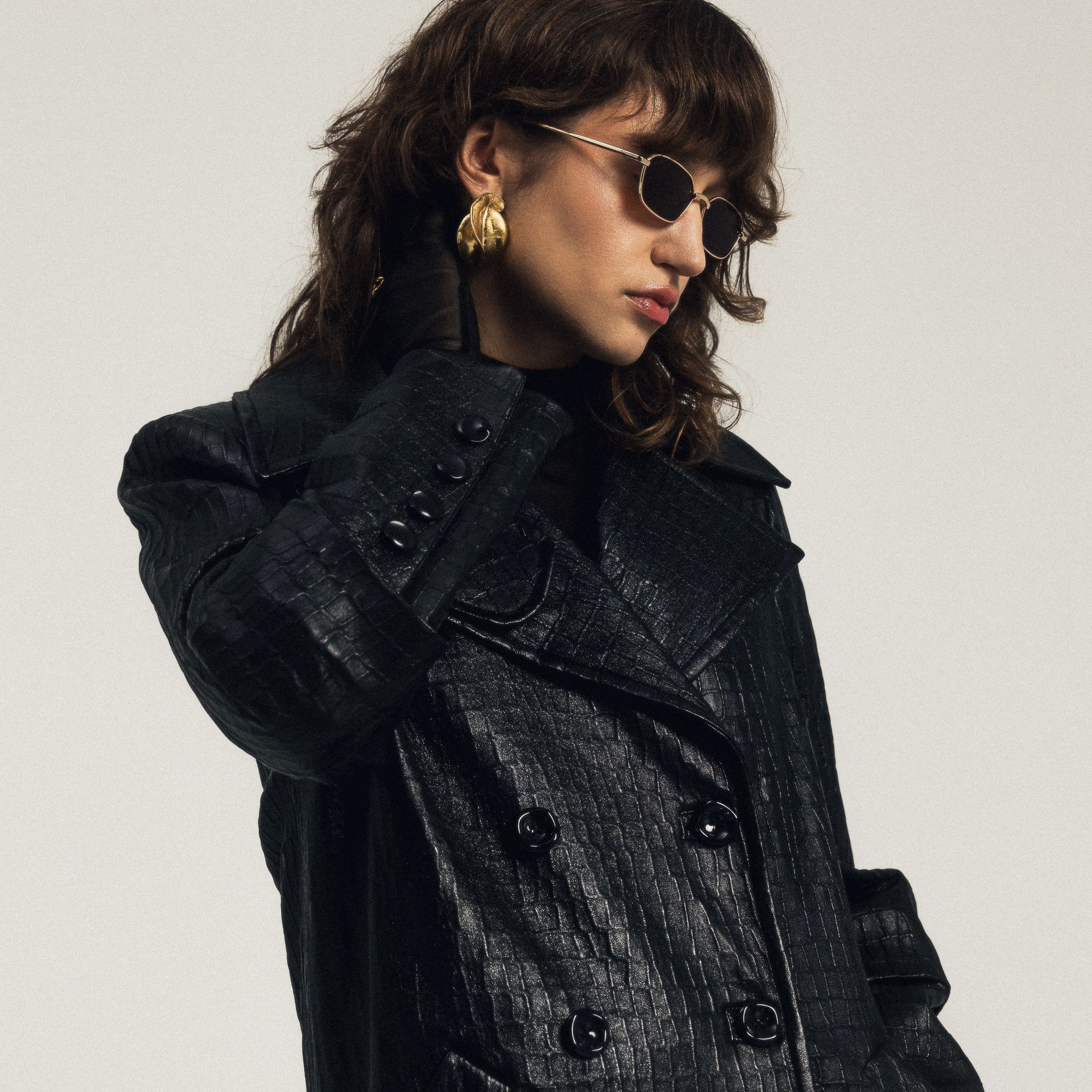 Kobieta w okularach przeciwsłonecznych i czarnym płaszczu