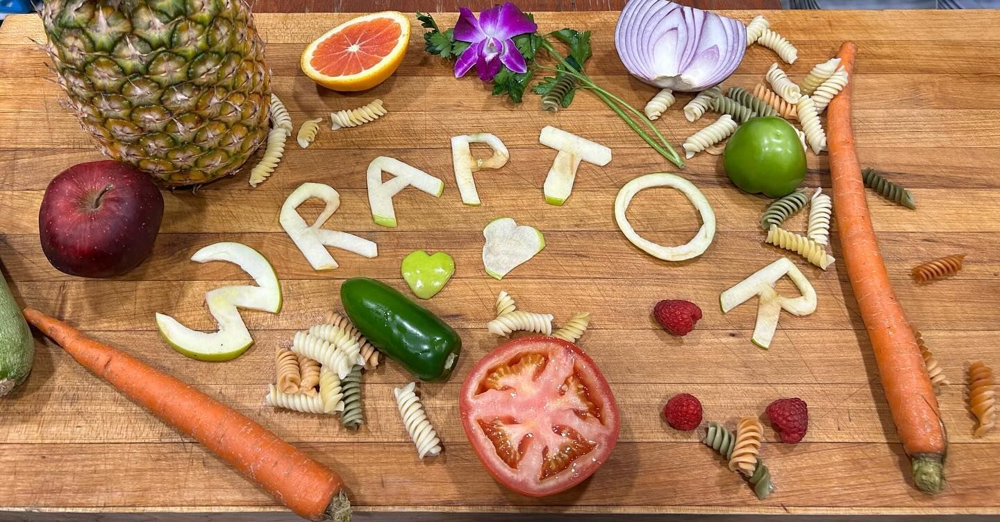 Fruits and vegetables arranged on a wooden surface to spell 