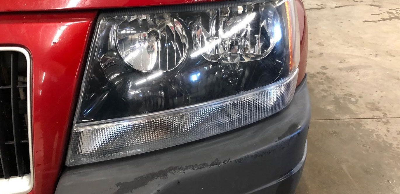 A close up of a red car 's headlight in a garage.