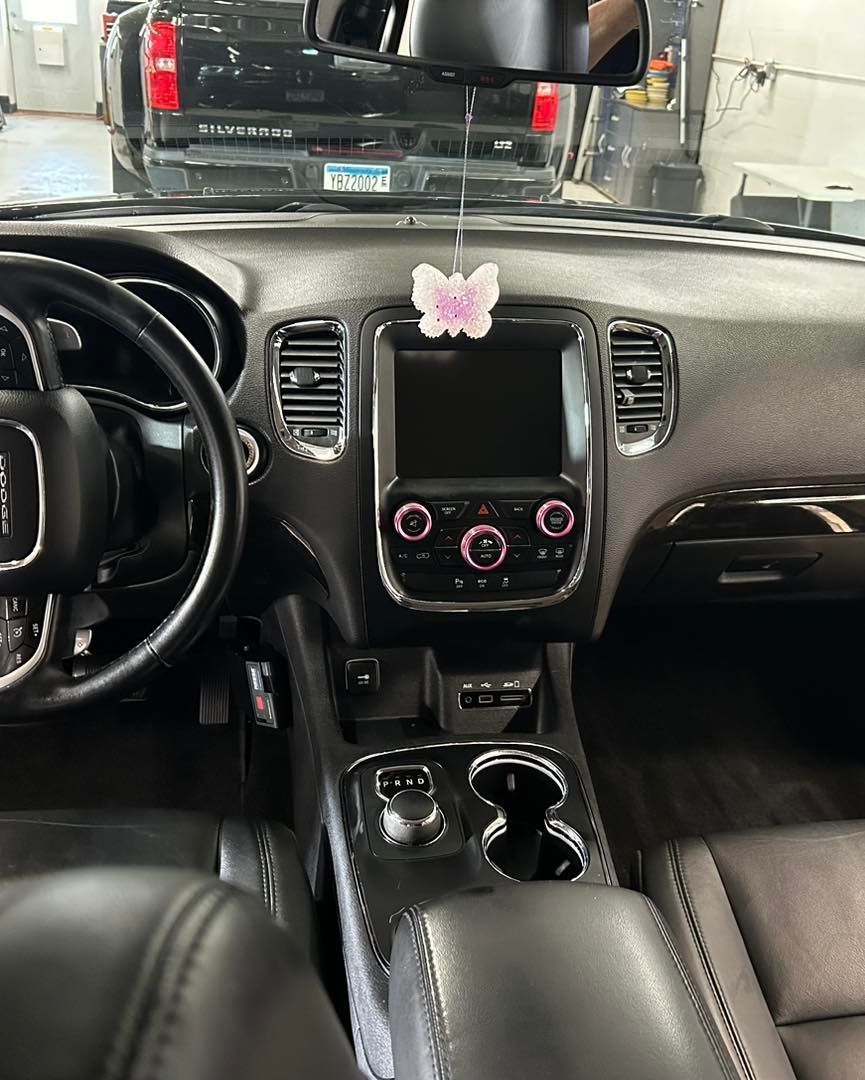 The interior of a dodge durango with a flower on the dashboard.