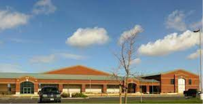 a car is parked in front of a large brick building .