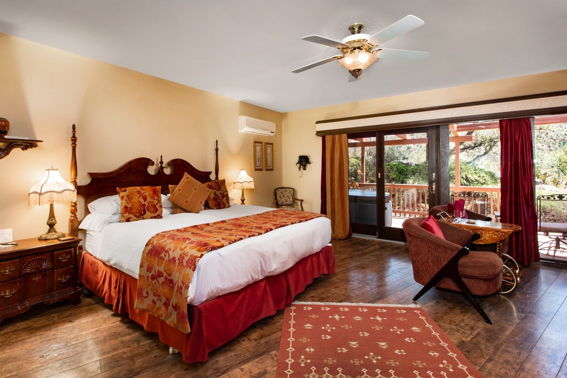 A hotel room with a king size bed and a ceiling fan