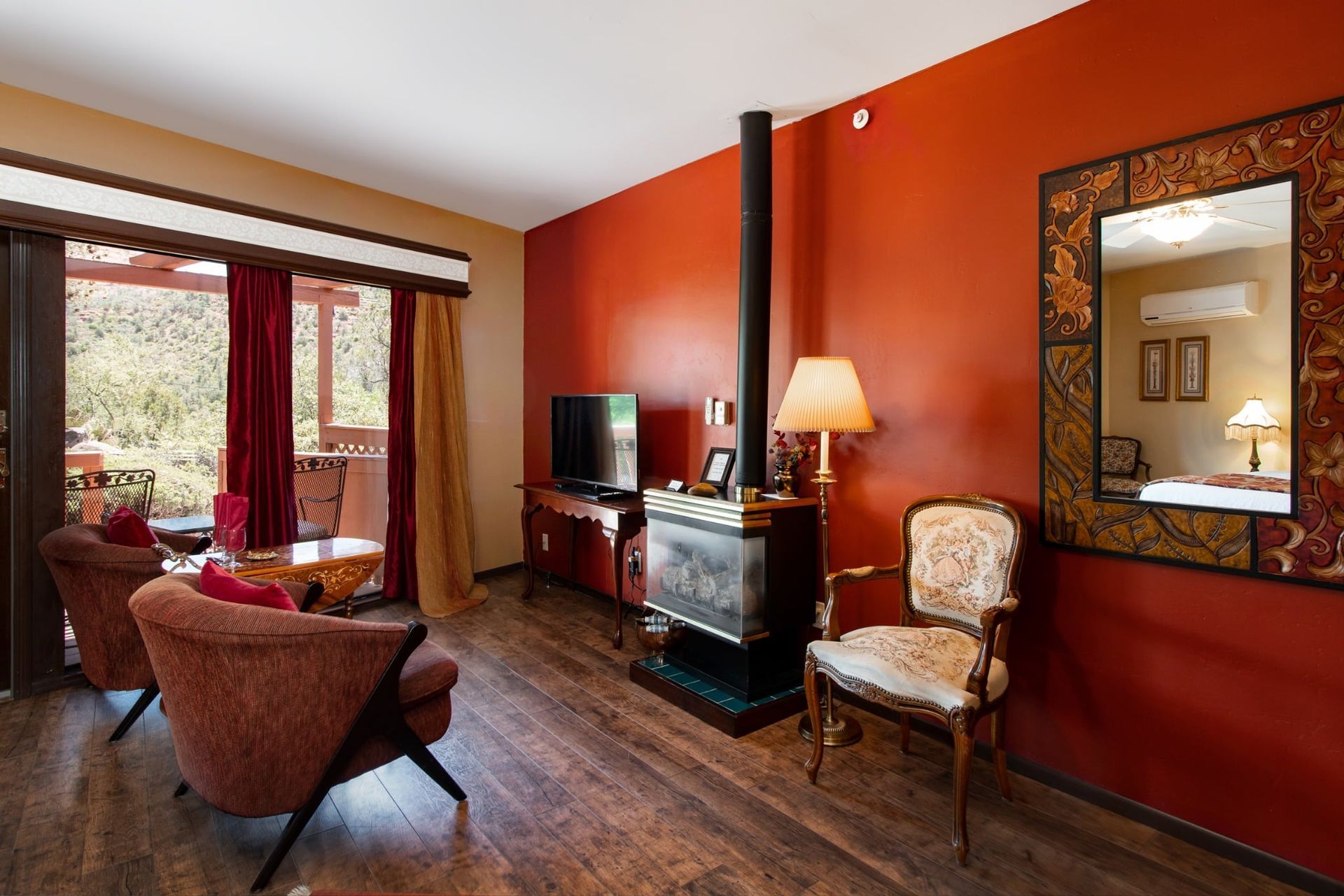 A living room with red walls and a fireplace