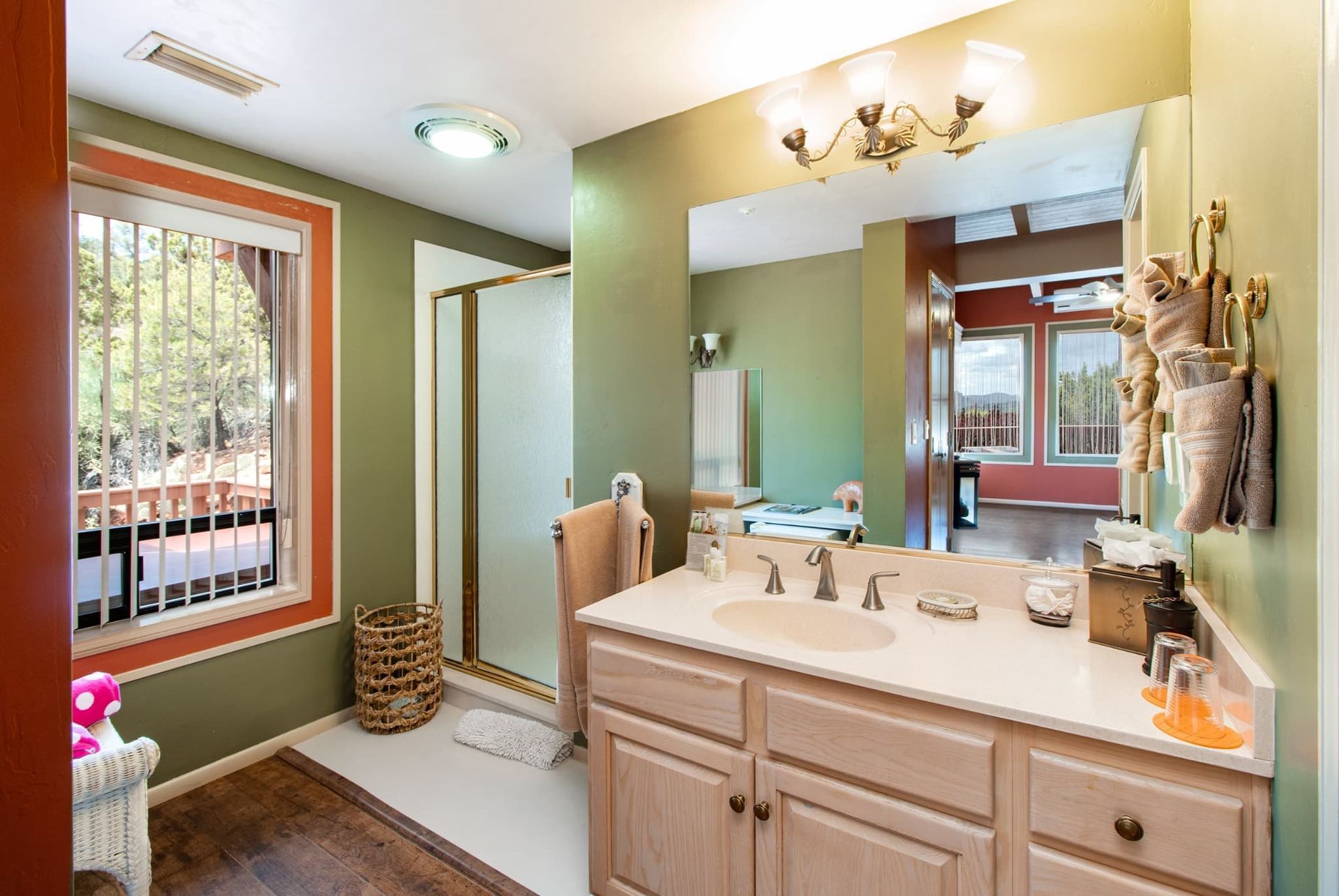 A bathroom with a sink , mirror , and window.