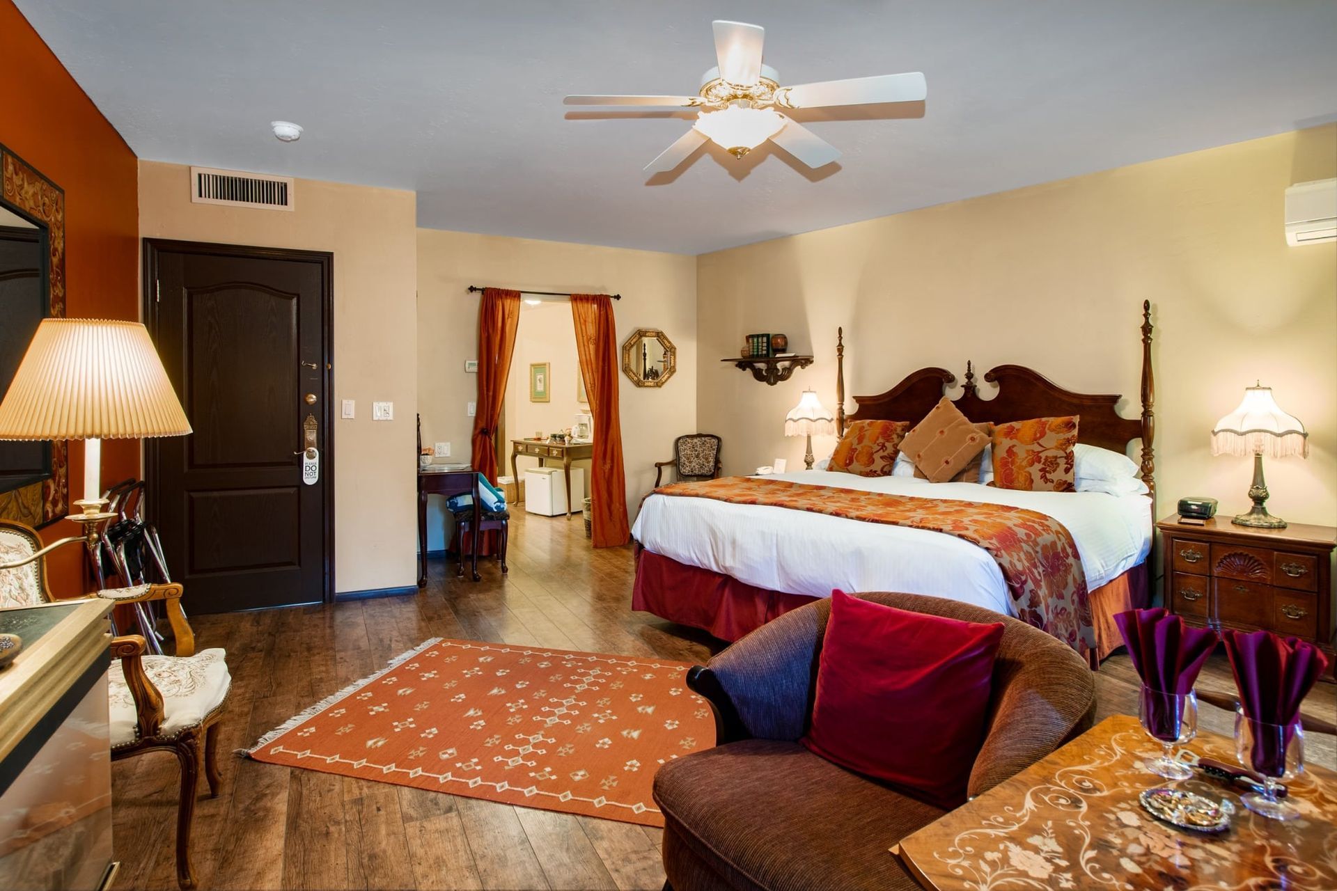 A hotel room with a large bed and a ceiling fan