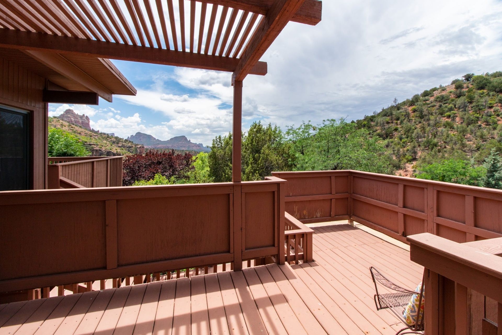 A wooden deck with a pergola and a view of the mountains.