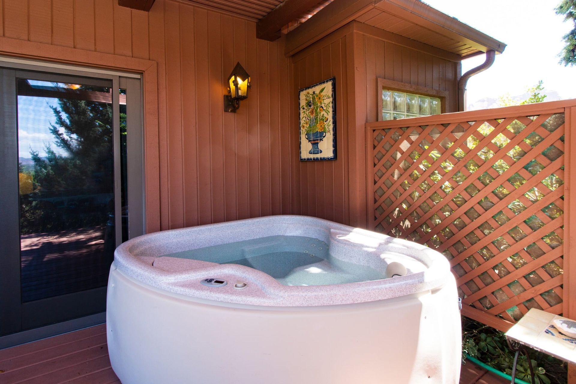 A white hot tub is sitting outside of a house