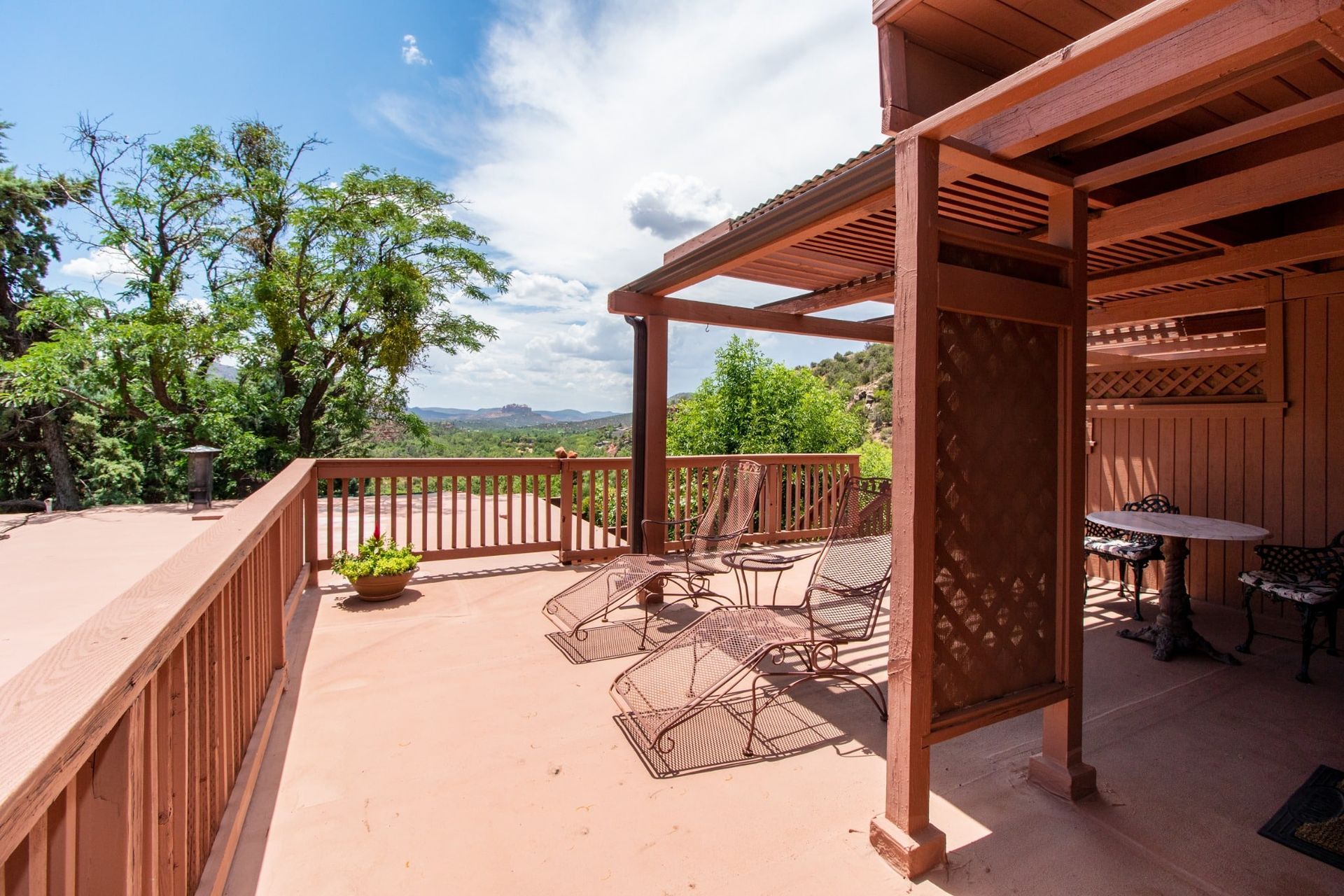 There is a large deck with a table and chairs on it.