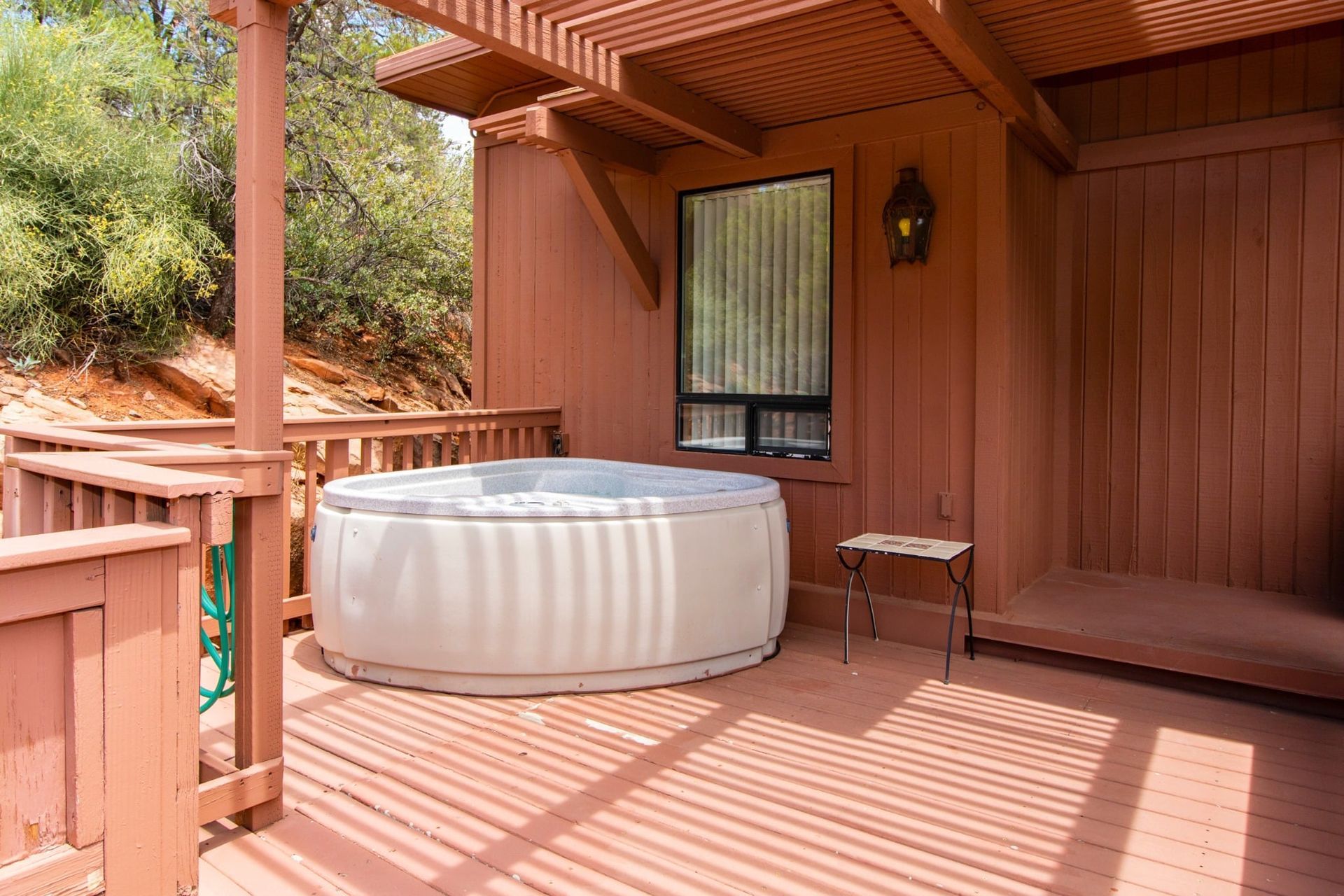 There is a hot tub on the deck of a house.