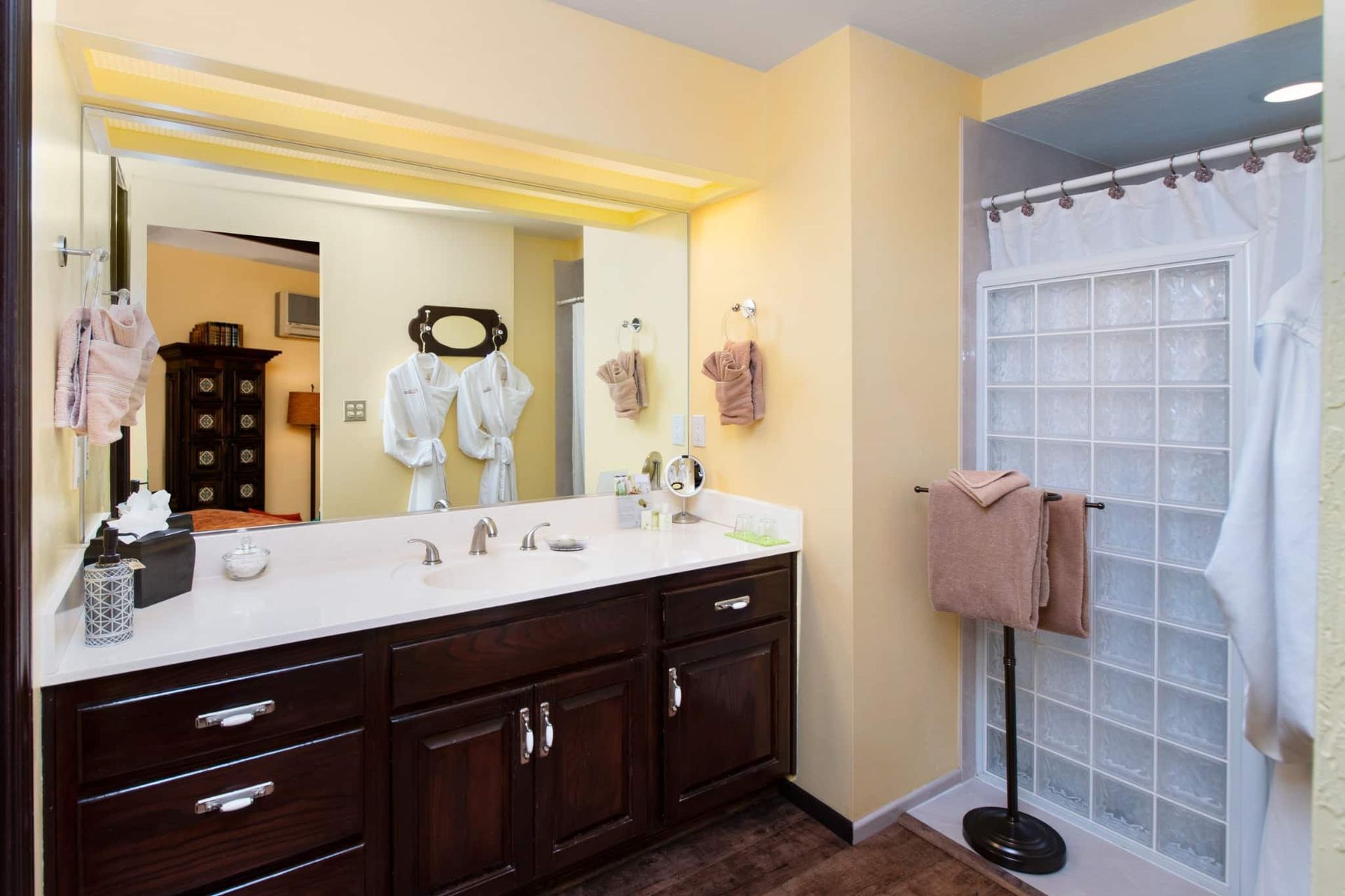 A bathroom with two sinks , a shower and a mirror.