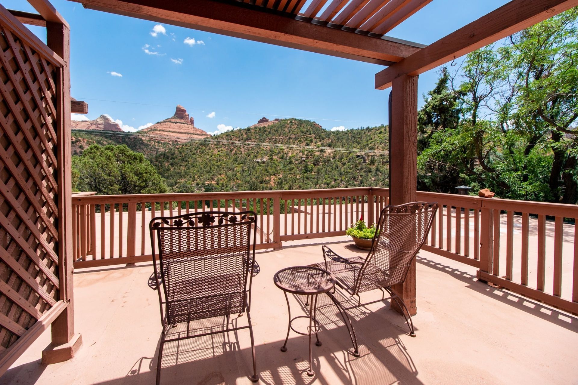 A deck with chairs and a table with a view of mountains