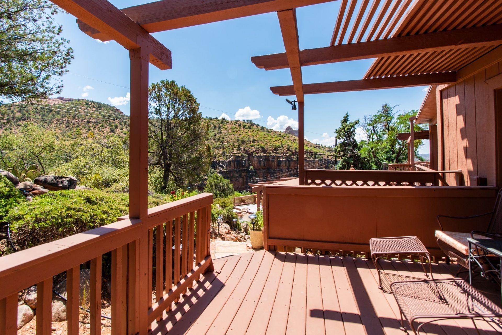 A wooden deck with a pergola and a view of the mountains