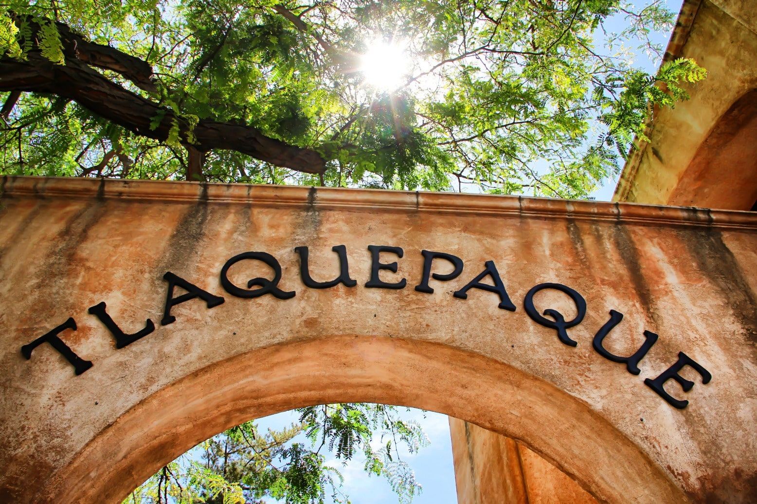 A stone archway with the word tlaquepaque written on it