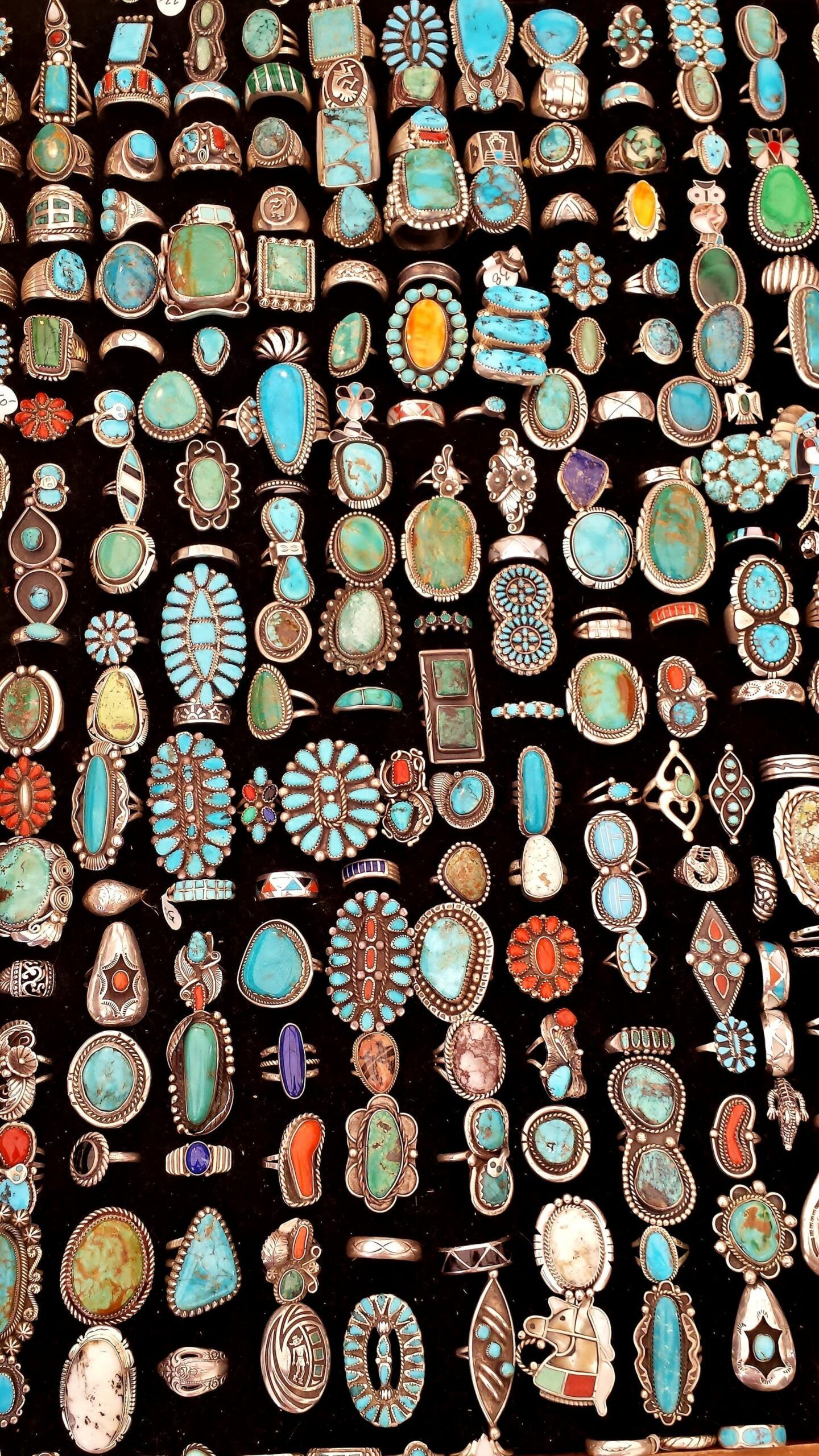 There are many different types of turquoise rings on display.