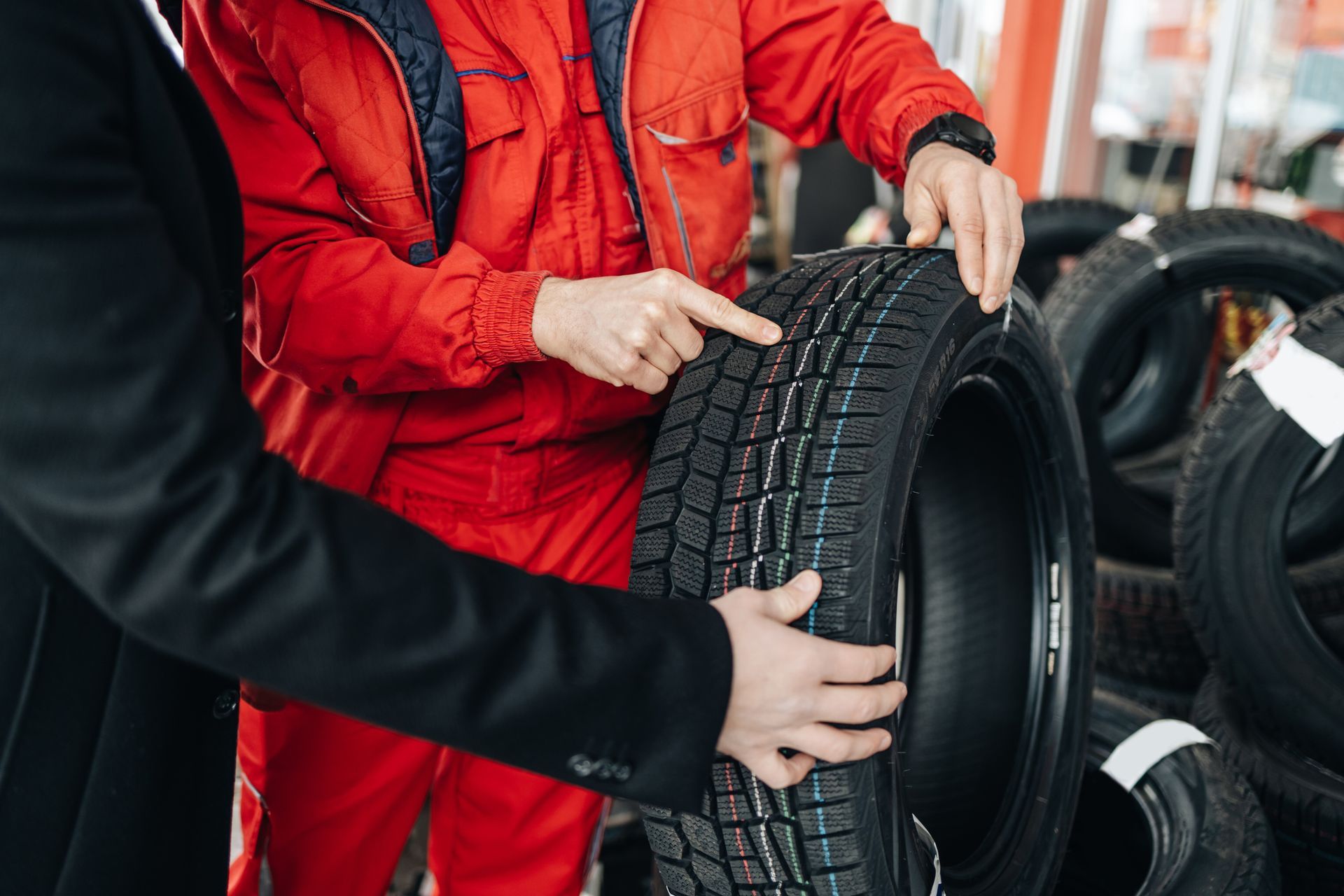 A man and a woman are looking at a tire in a tire store.