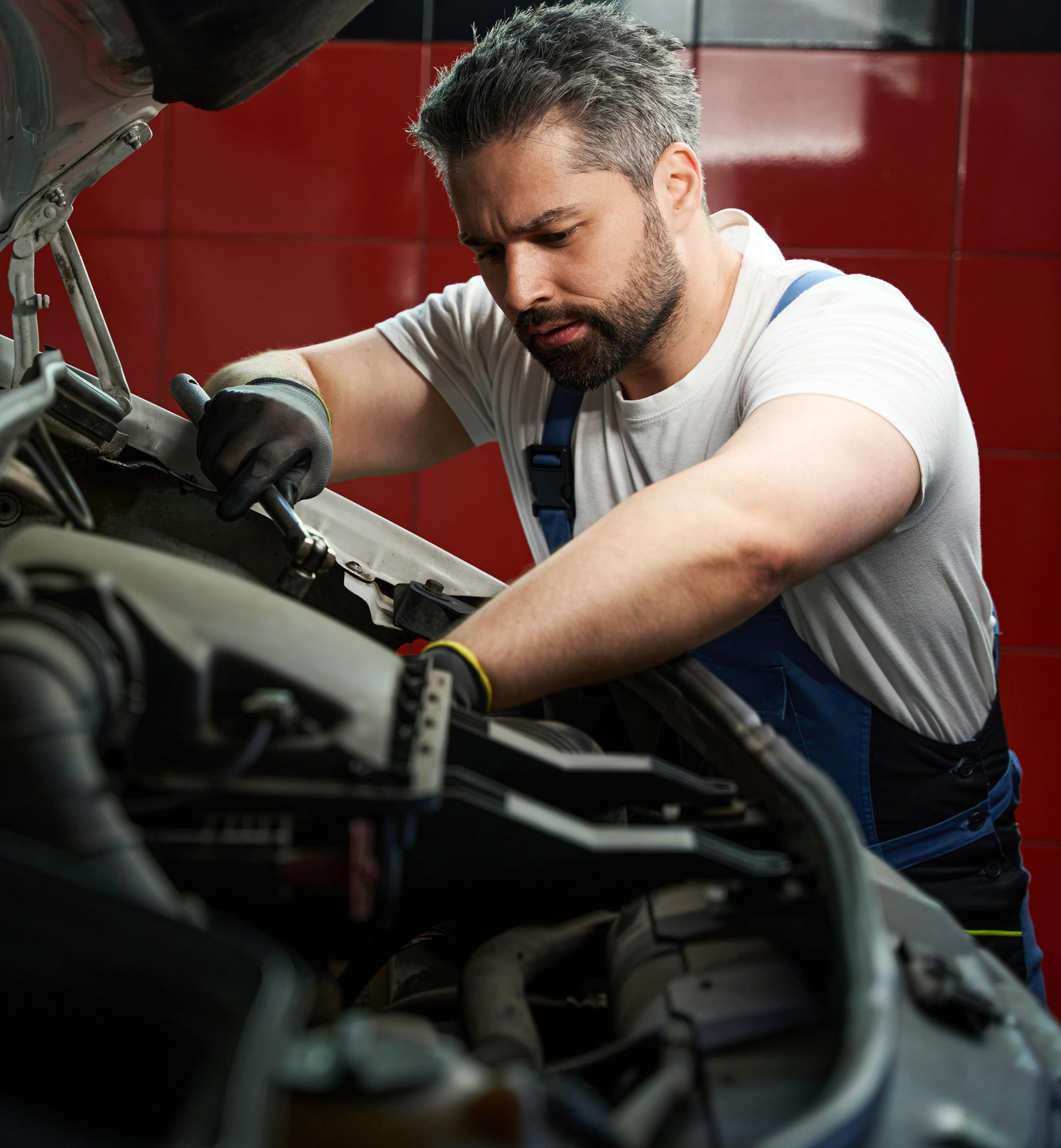 A man is working under the hood of a car