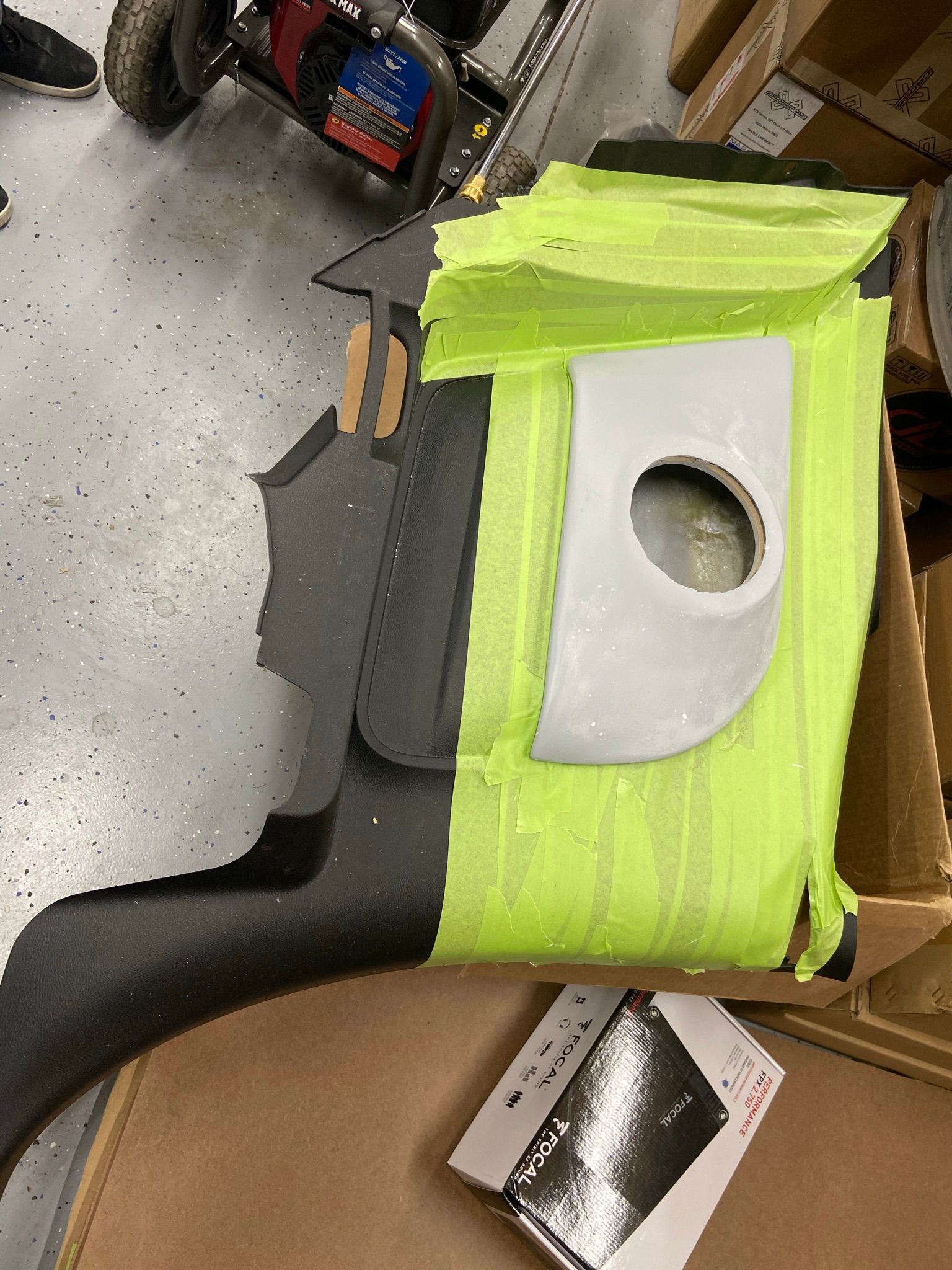 A piece of plastic is taped to a box in a garage.