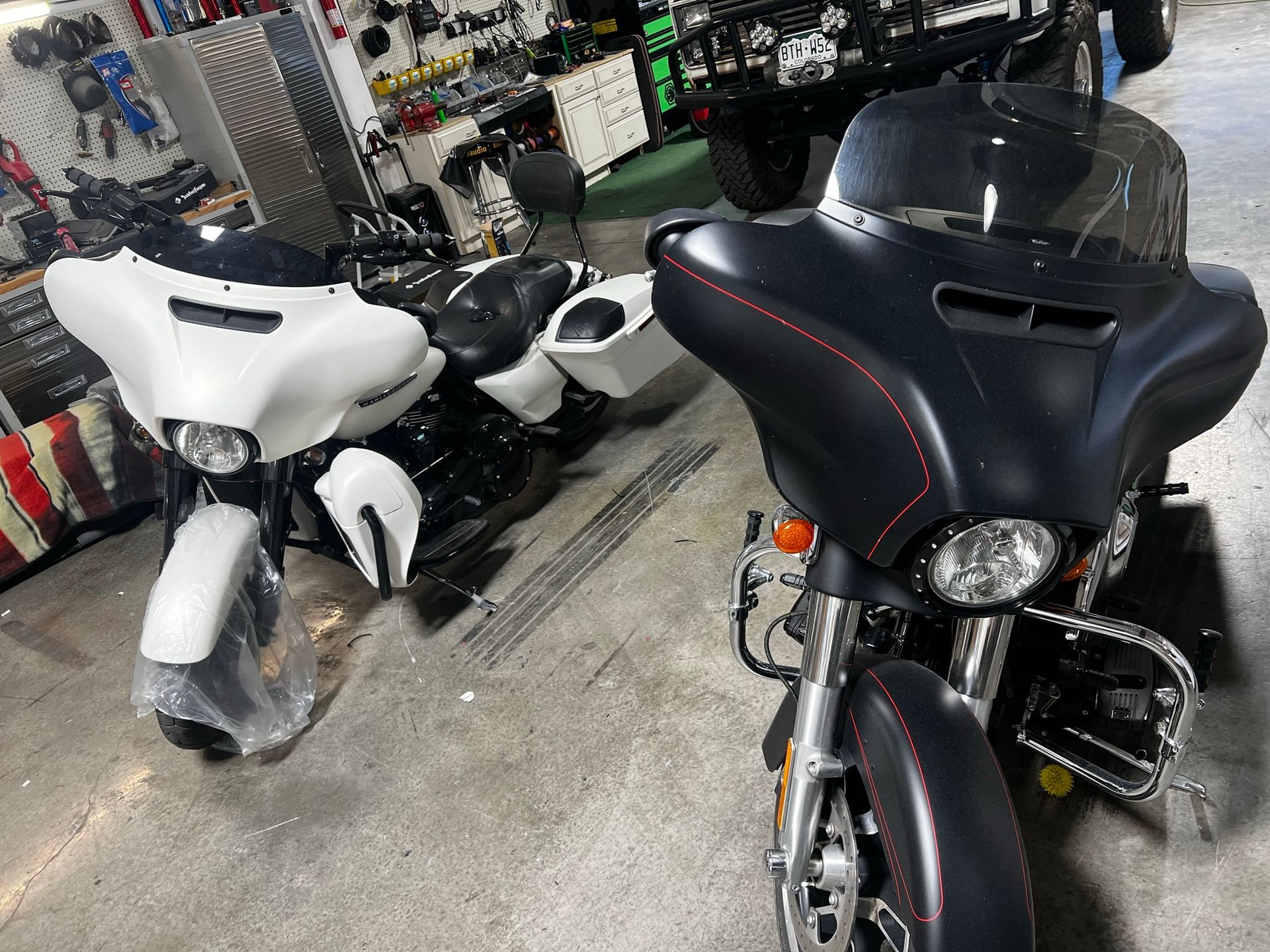 Two motorcycles are parked next to each other in a garage.