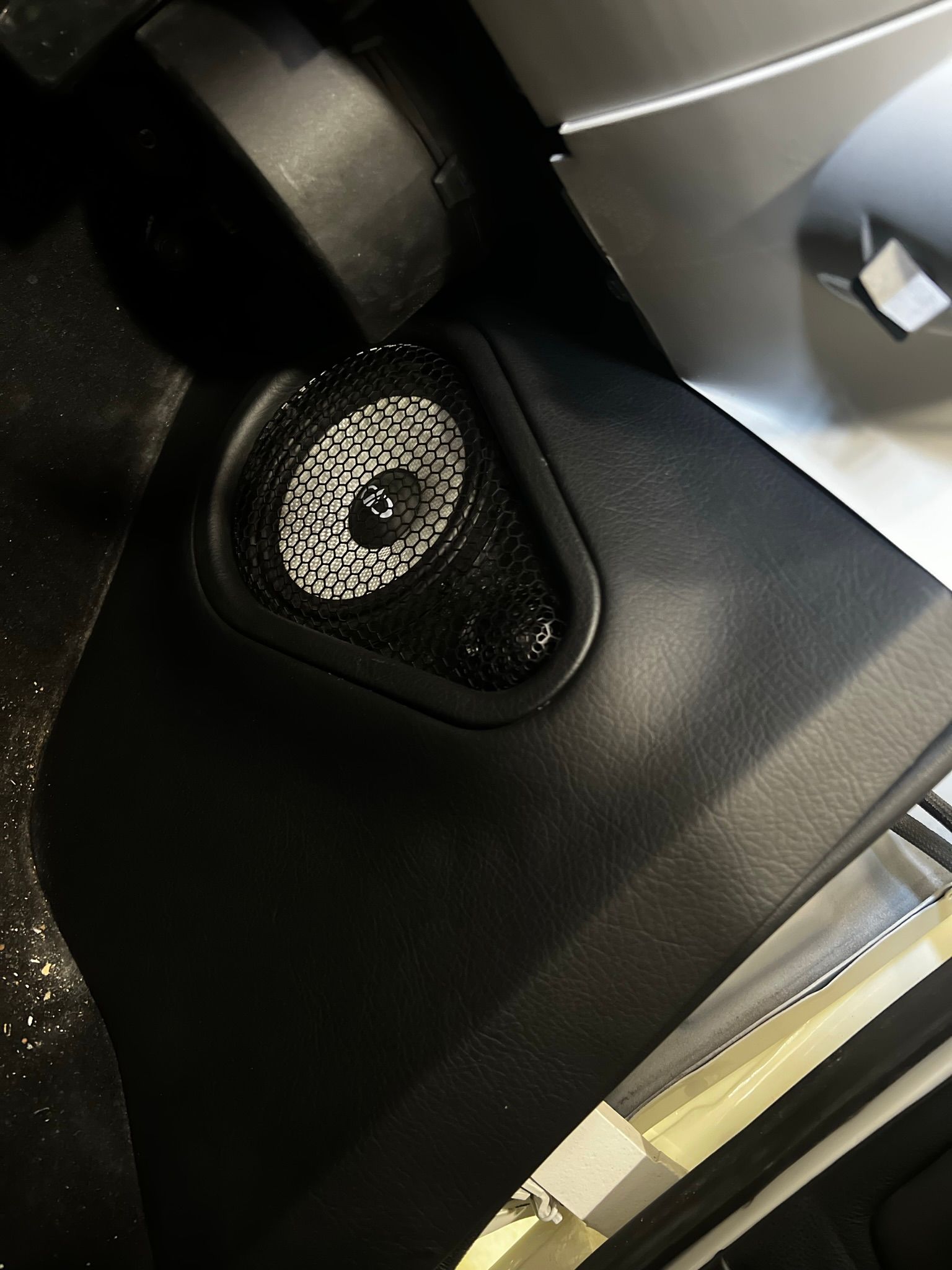 A close up of a speaker on the side of a car.