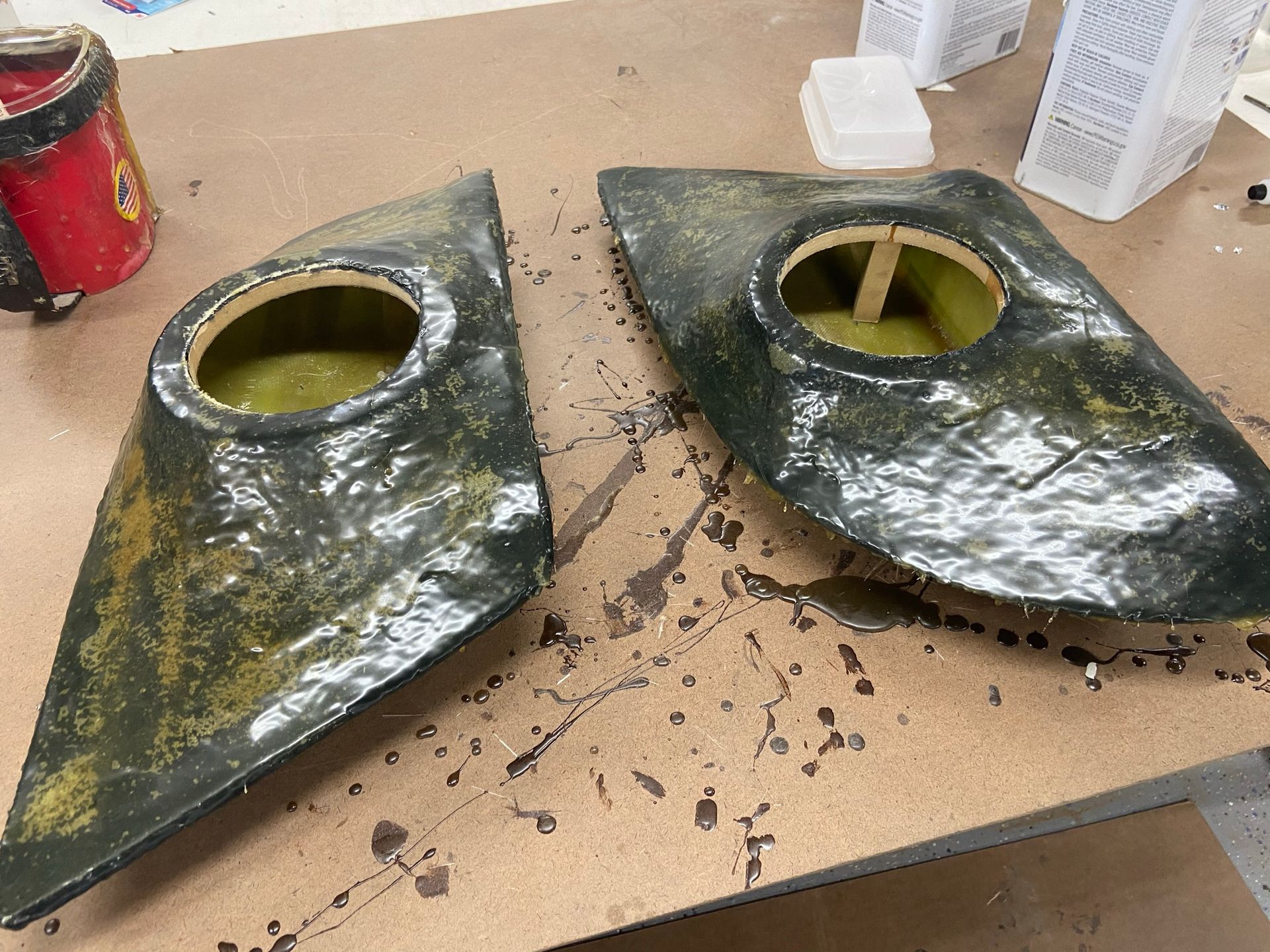 A pair of speaker covers are sitting on a wooden table.