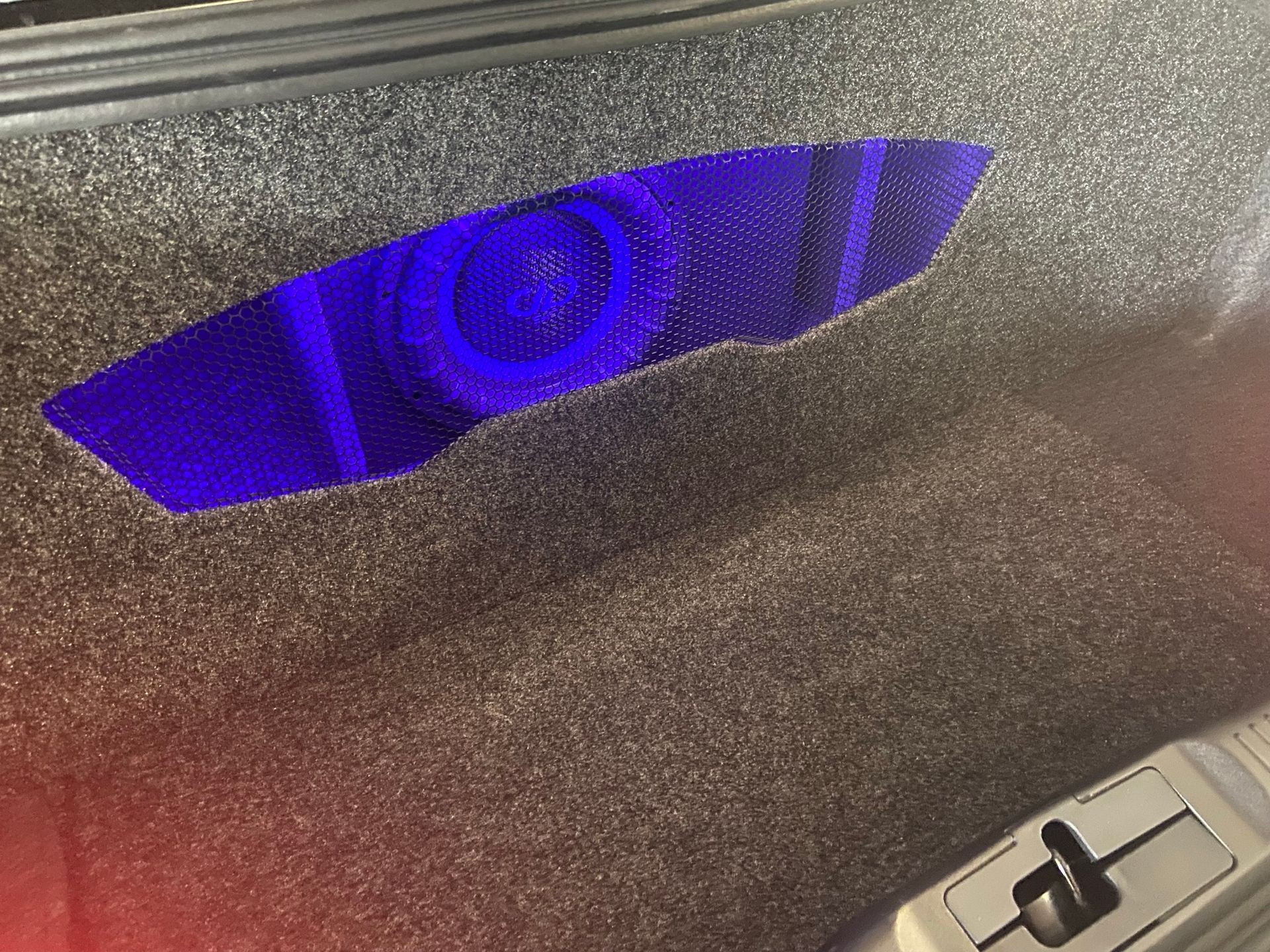 A purple light is shining through a hole in a box