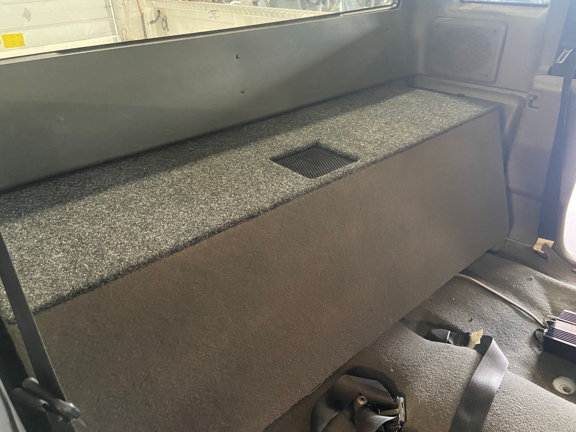 The back seat of a truck with a seat belt on it.