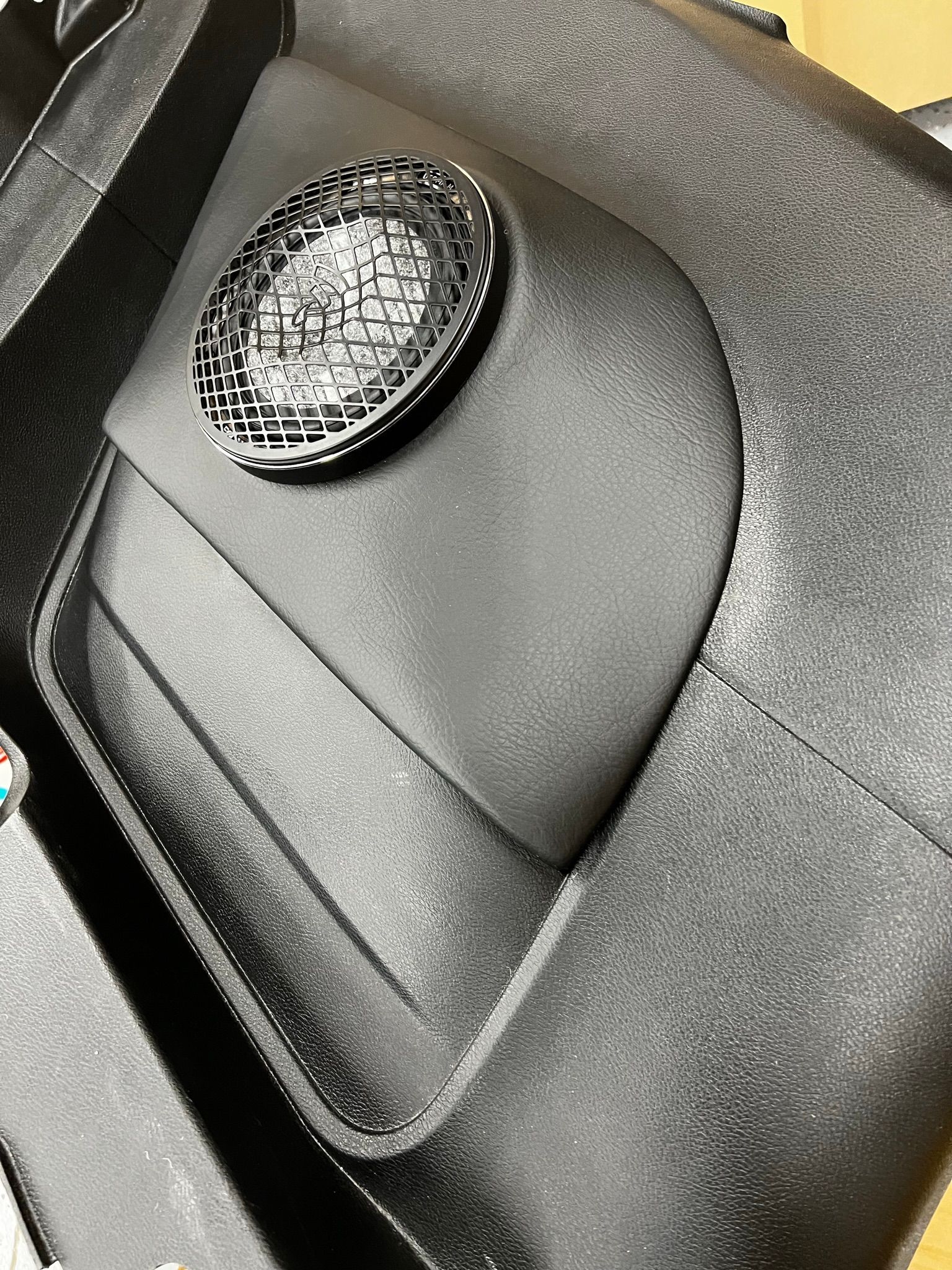 A close up of a speaker on a black object.