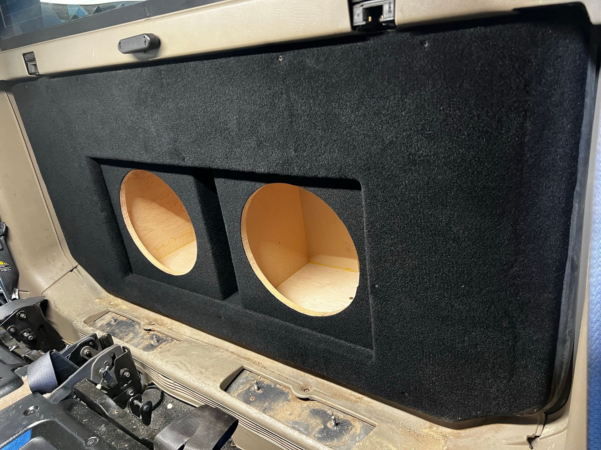 A subwoofer box is sitting in the back of a car.