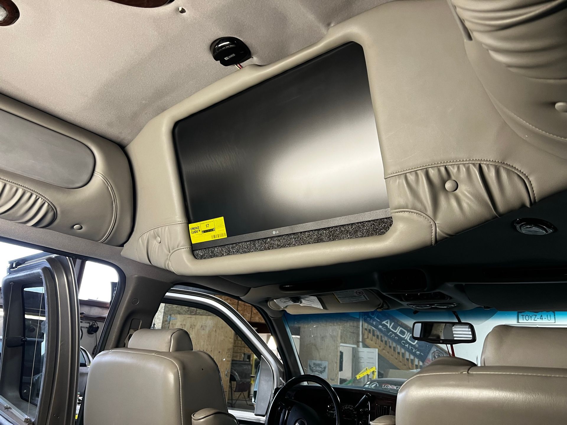 A car with a flat screen tv mounted to the ceiling