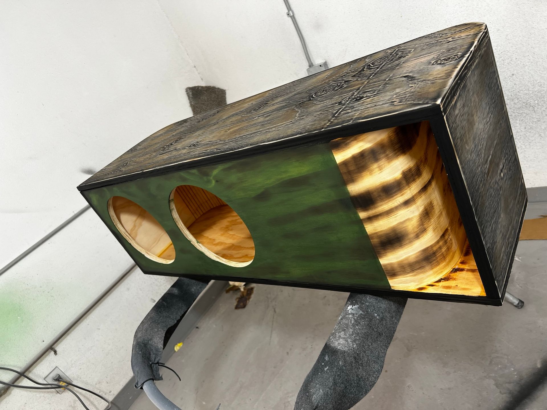 A green box with three holes in it is sitting on a table