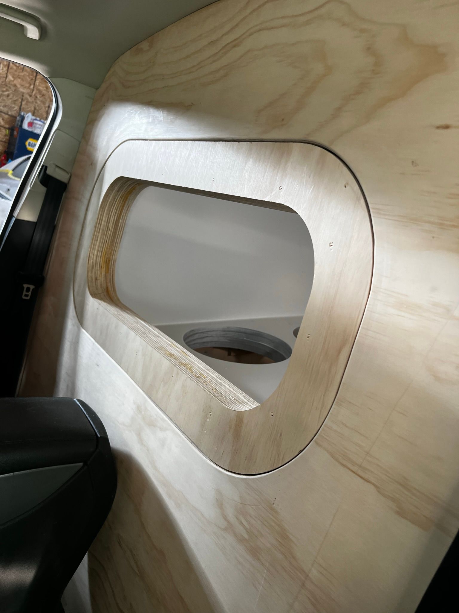 A wooden wall with a hole in it that looks like a window.