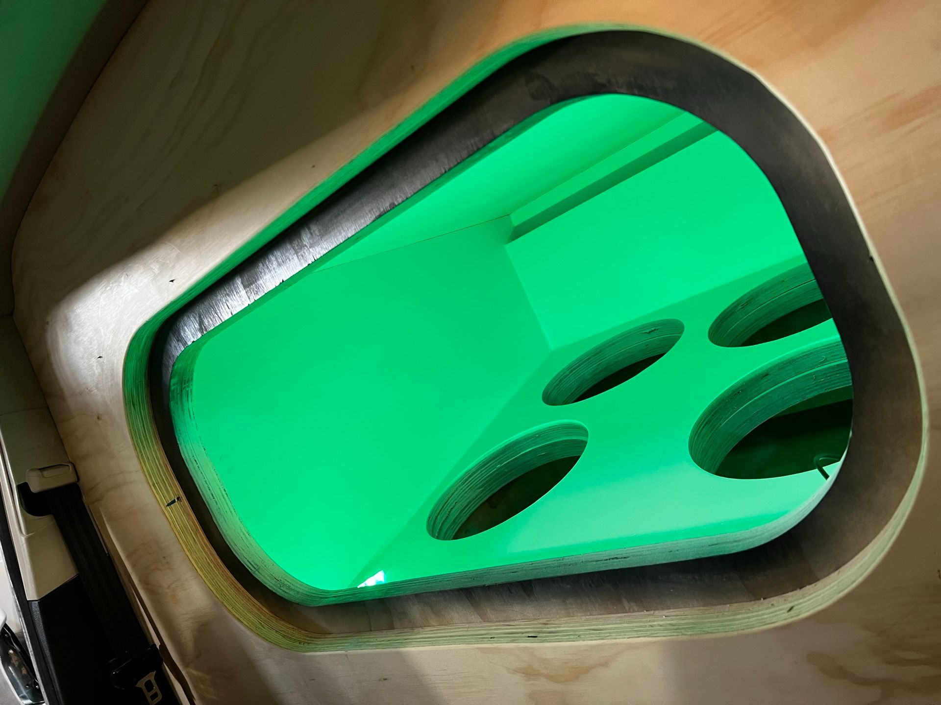 A green glass window with holes in it