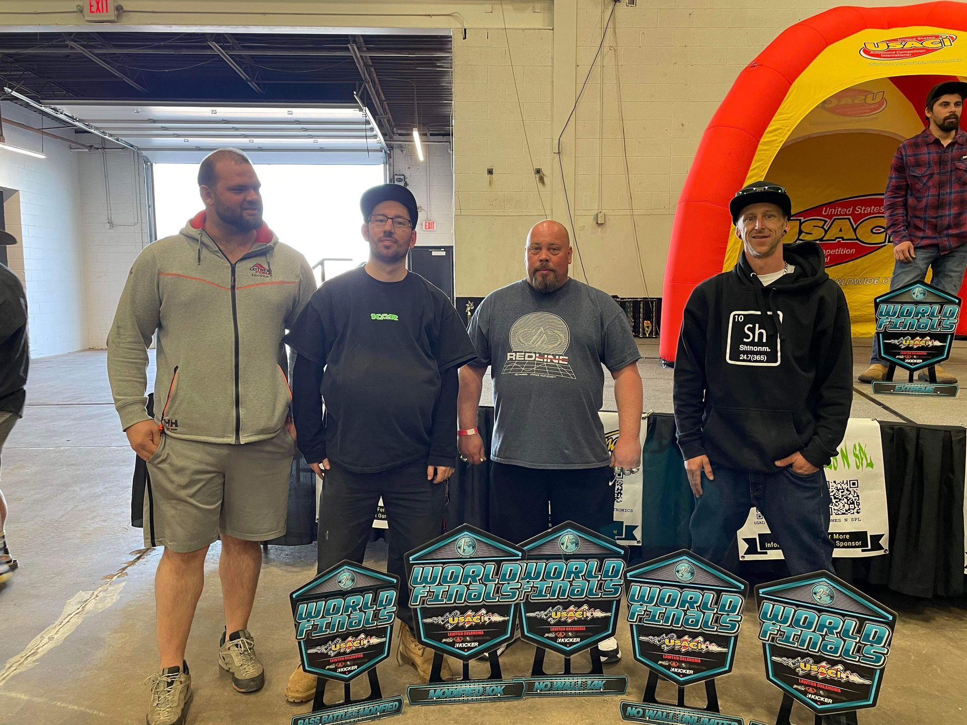 A group of men standing in front of trophies in a room.