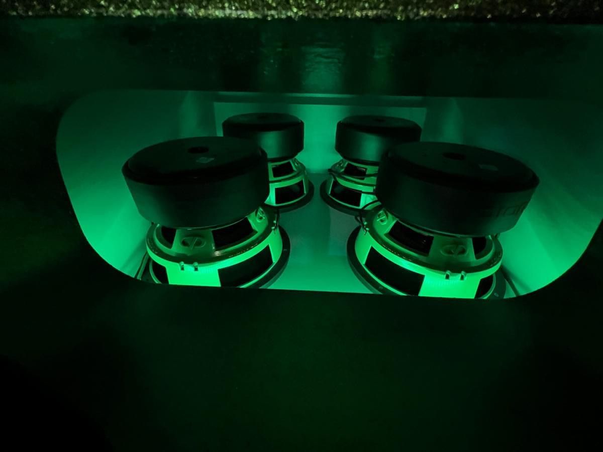 A bunch of speakers are lit up with green lights