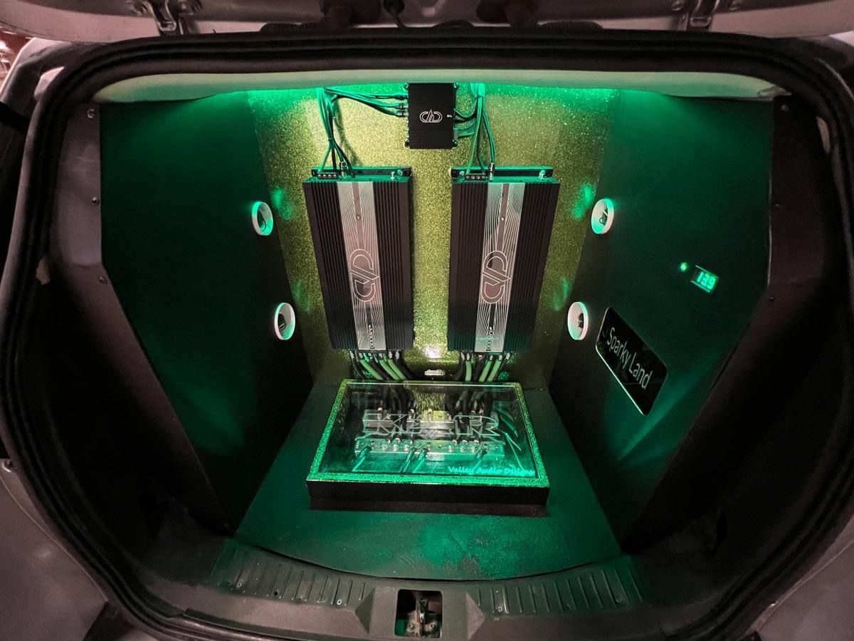 The trunk of a car with green lights on it