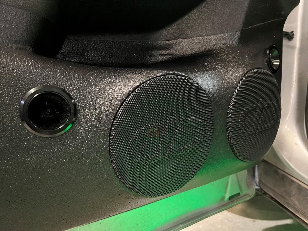A close up of a speaker in the door of a car.