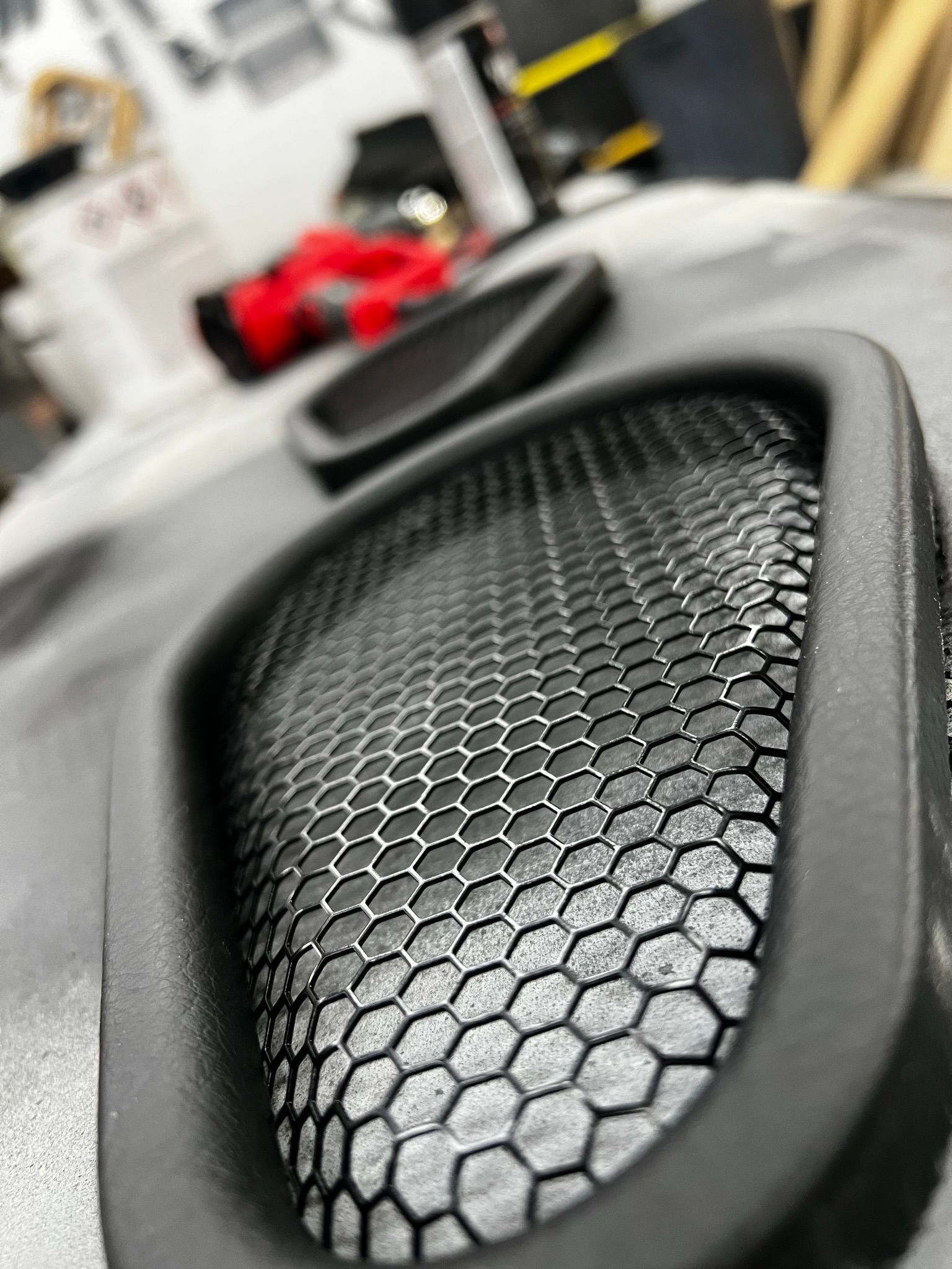 A close up of a speaker with a honeycomb pattern on it.