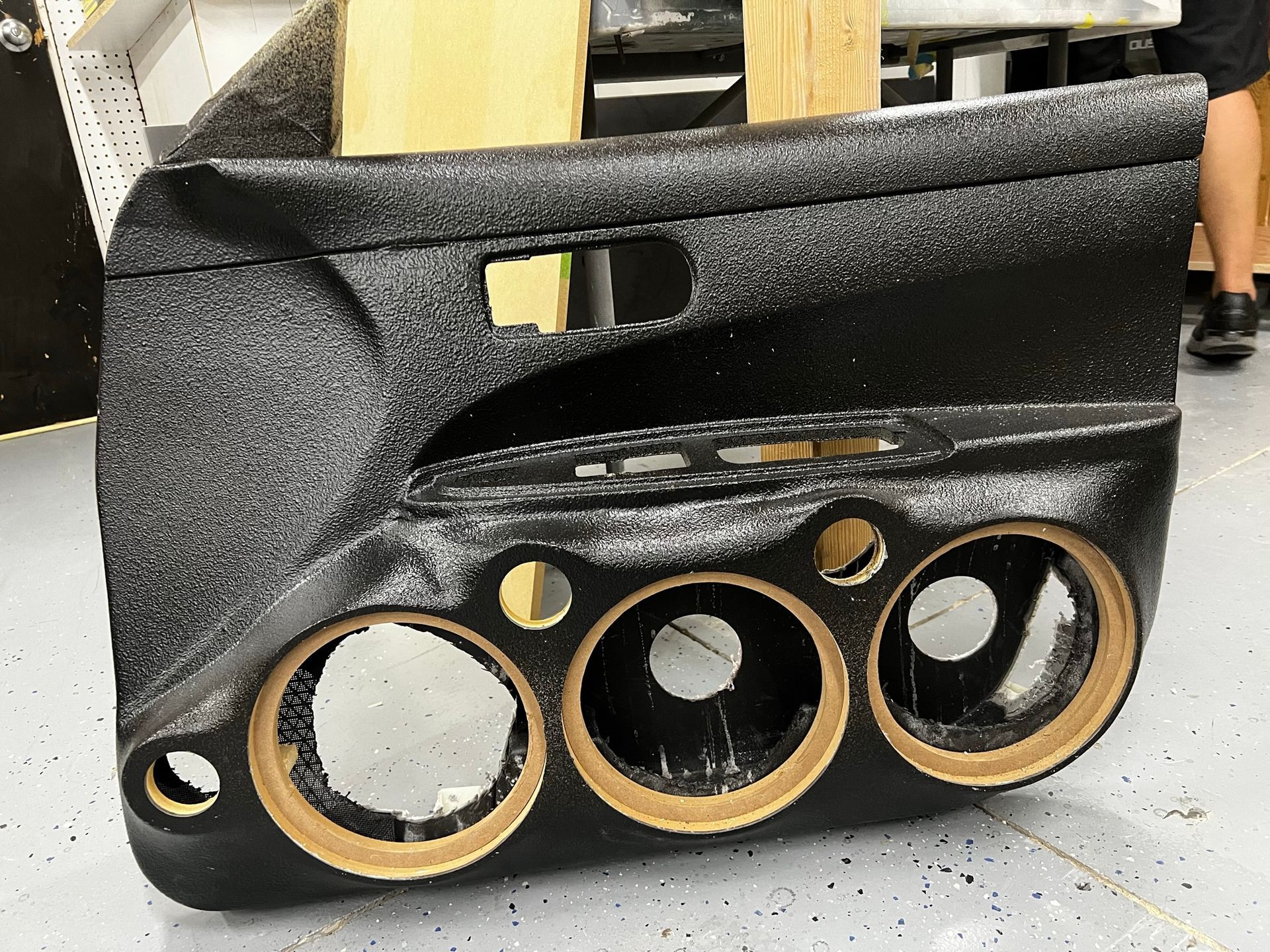 A black car door with holes in it