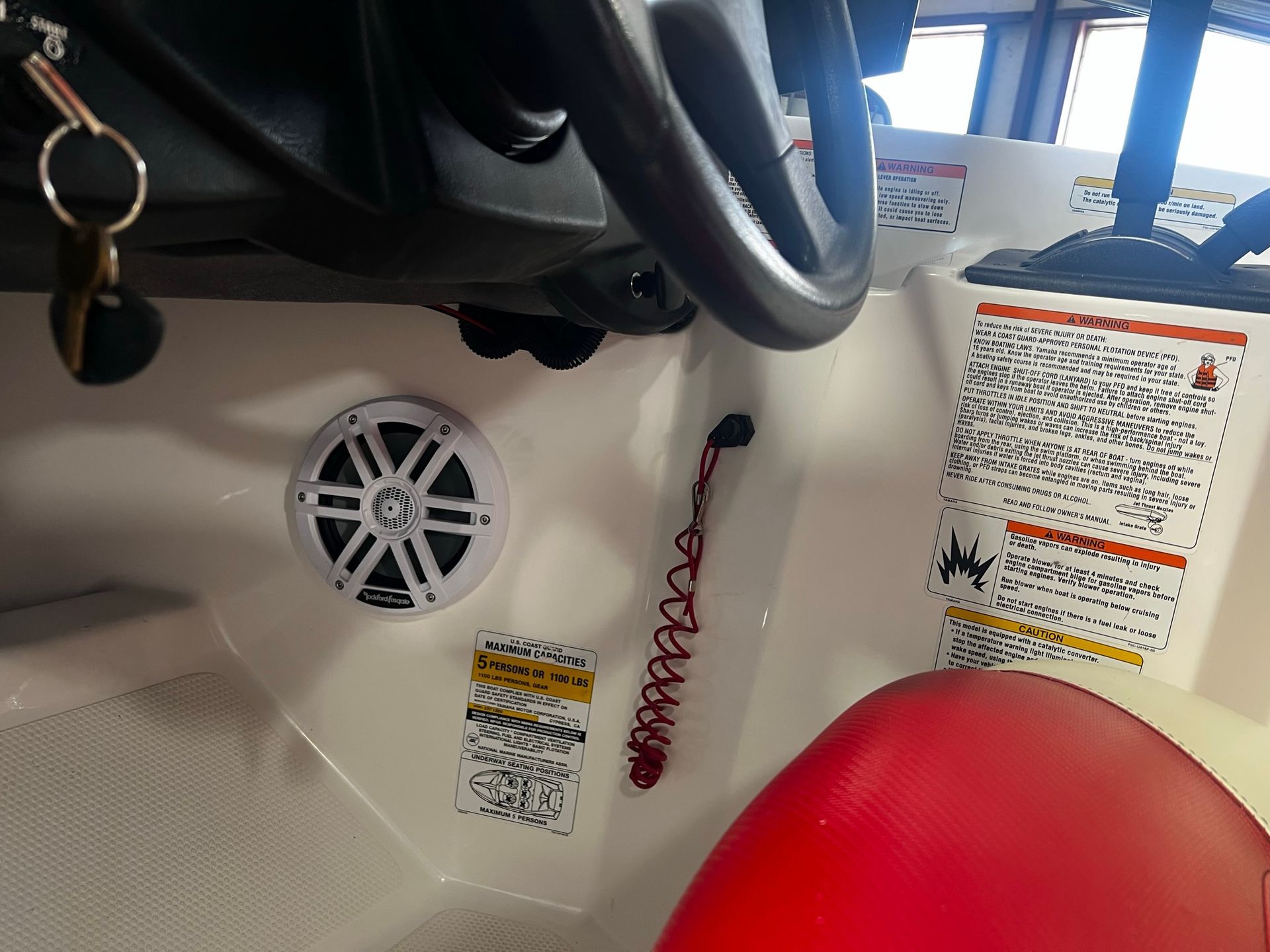 The inside of a boat with a speaker and steering wheel