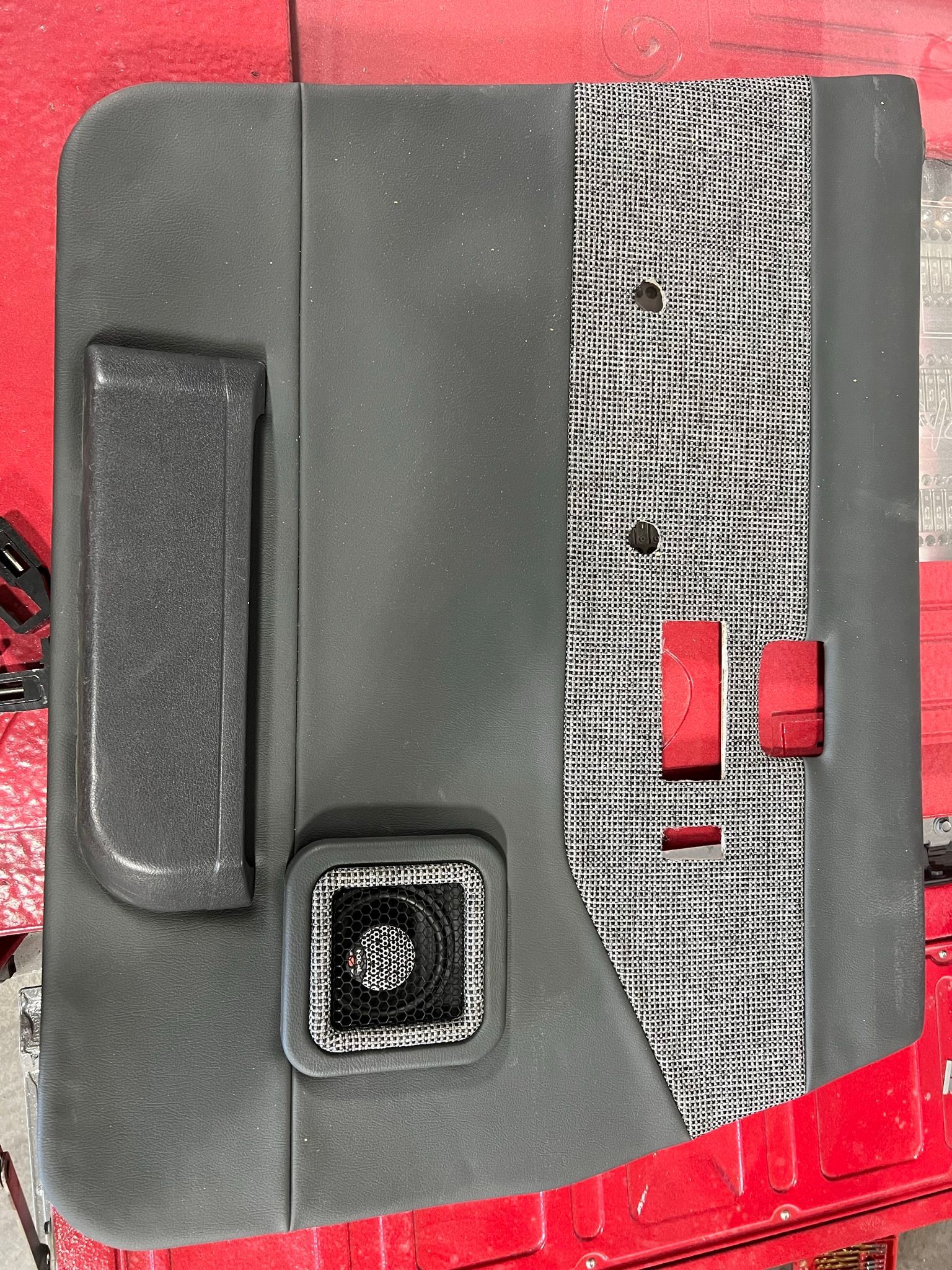 A close up of a door panel with a red button on it.