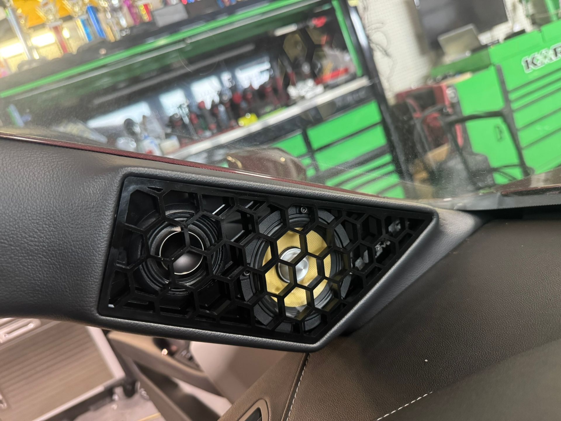 A close up of a speaker on the dashboard of a car.