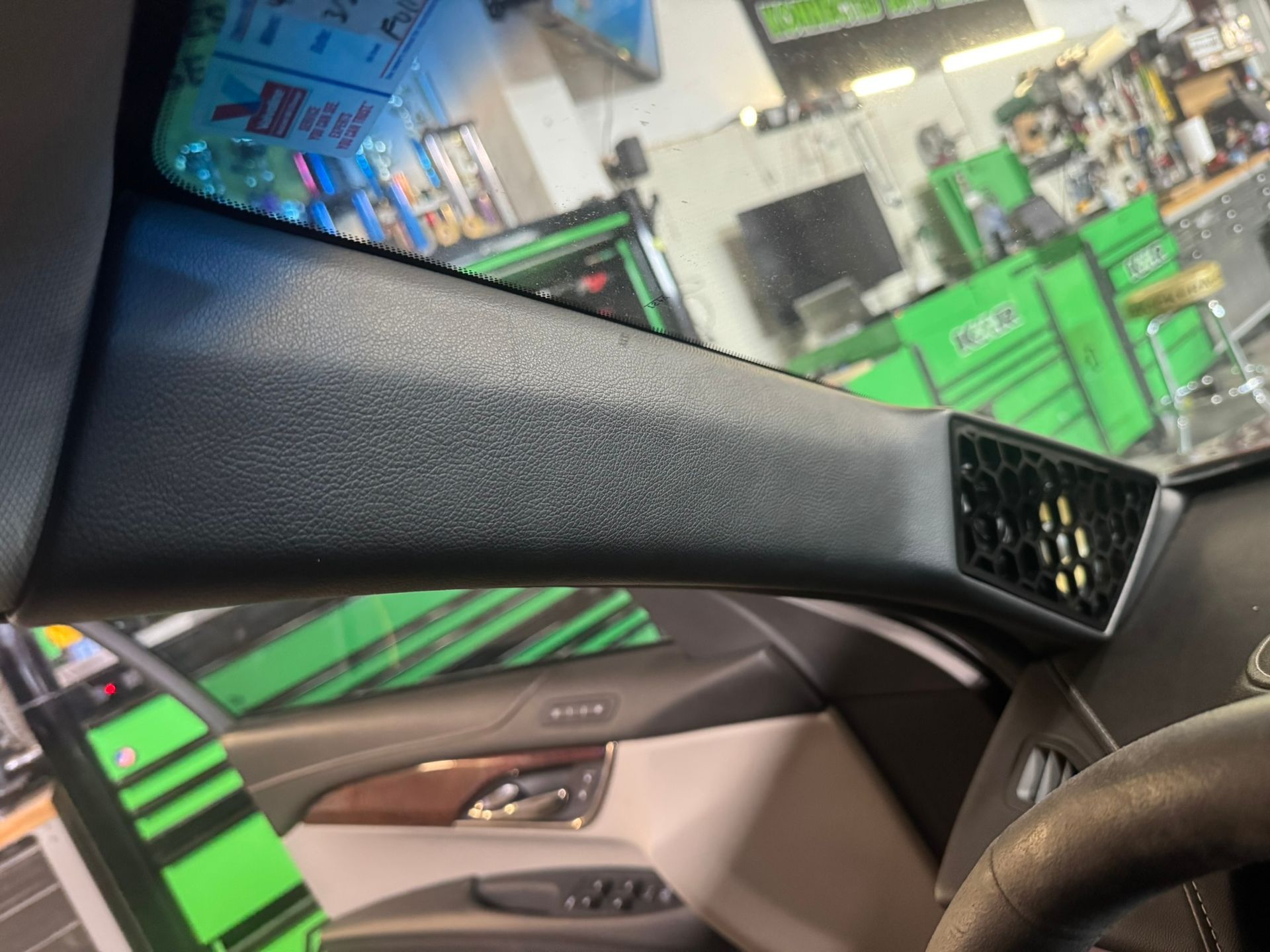A car is parked in a garage with a steering wheel and a dashboard.