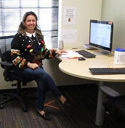 A woman is sitting at a desk in front of a computer.
