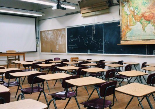 An empty classroom with a map on the wall