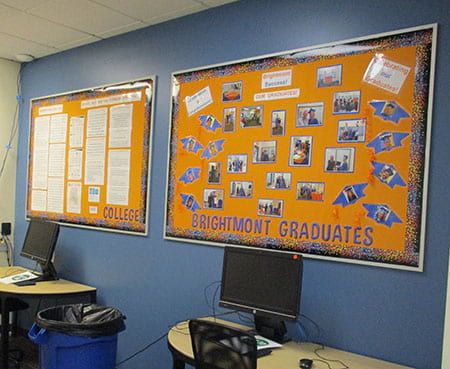 A bulletin board for brightmont graduates hangs on a blue wall